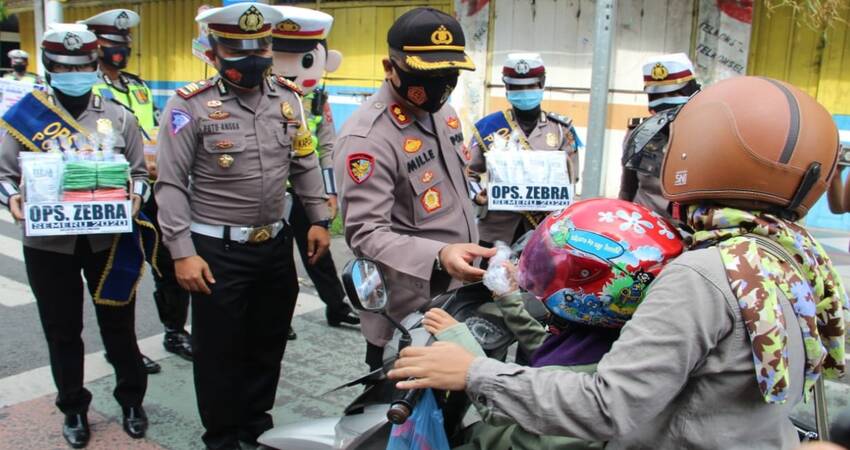 Kapolres Lumajang, AKBP Deddy Foury Millewa bersama anggota Satlantas membagi-bagikan kelengkapan standar protokol kesehatan (Prokes).